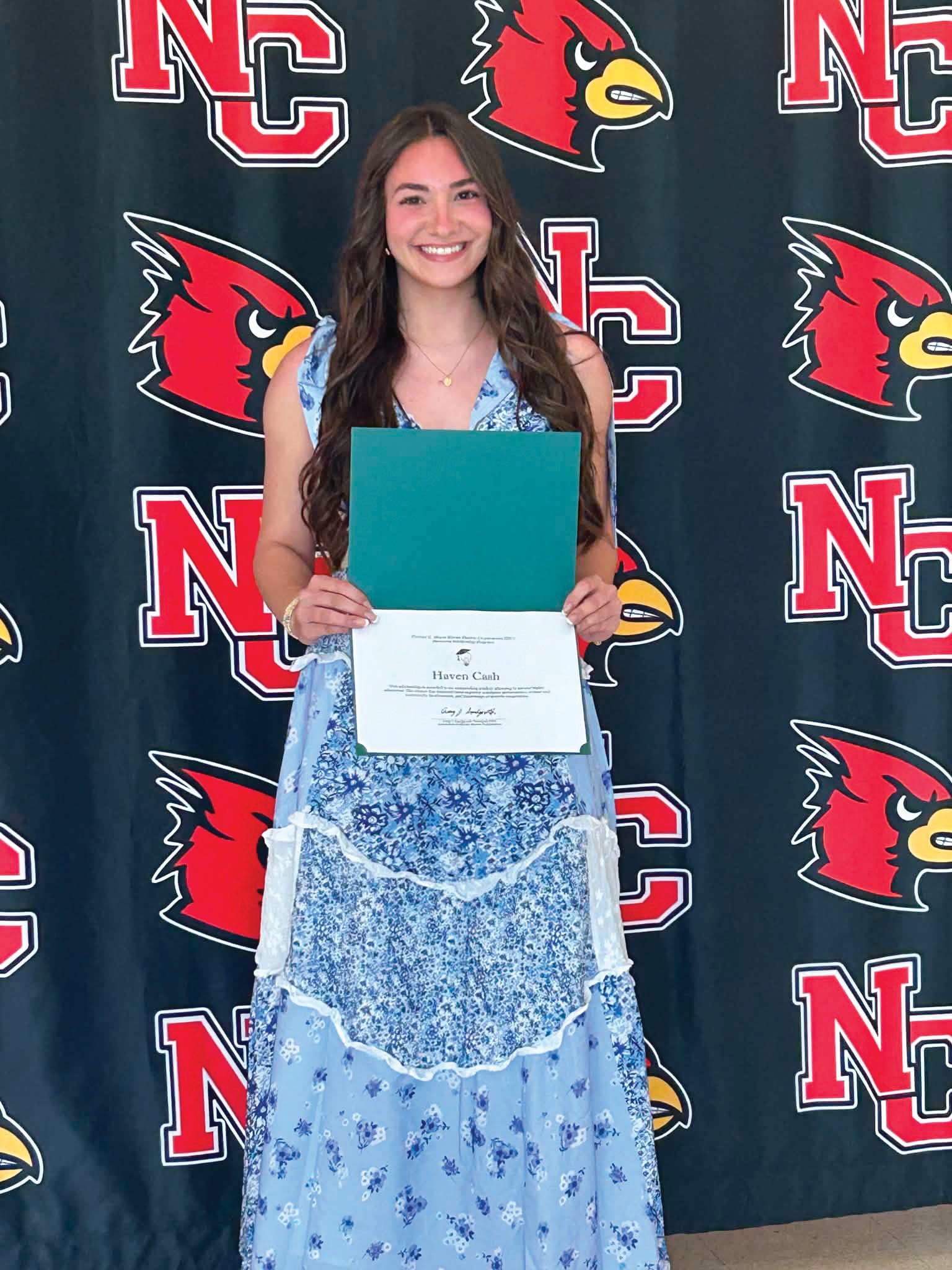 High school senior girl happily holds a scholarship certificate