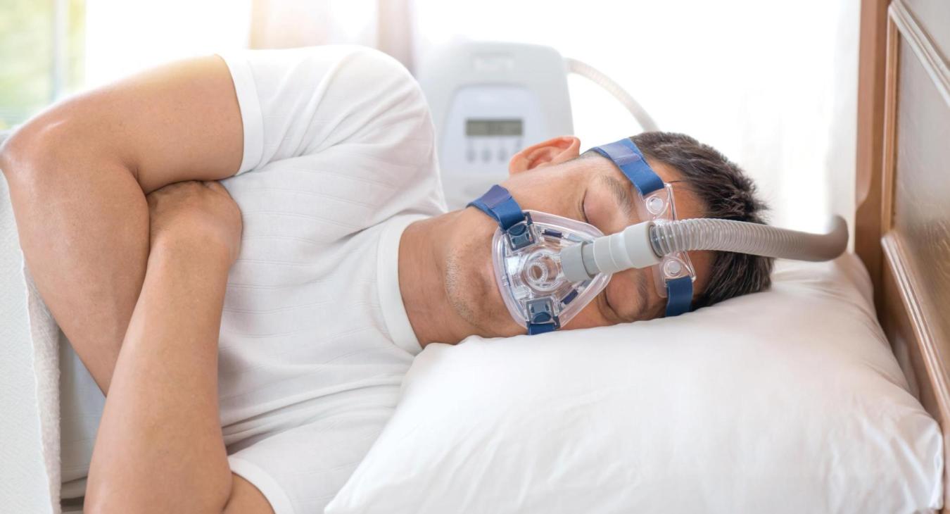Man sleeping with a CPAP machine